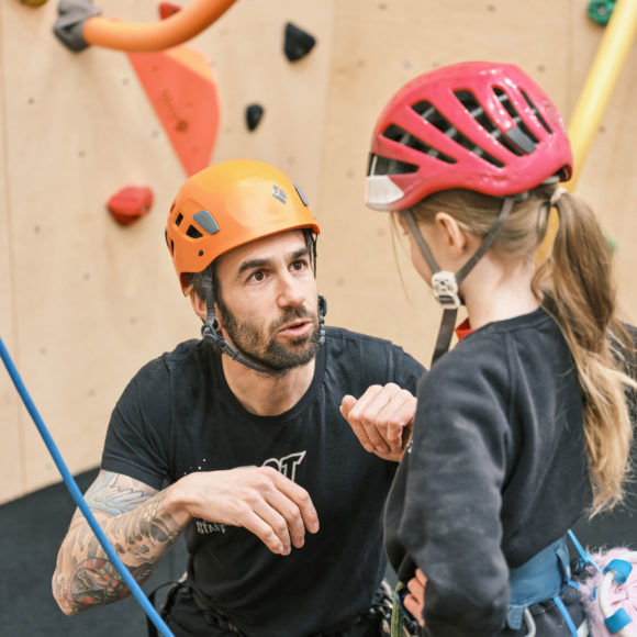 big depot summer camp participant receives guidance from depot climbing instructor