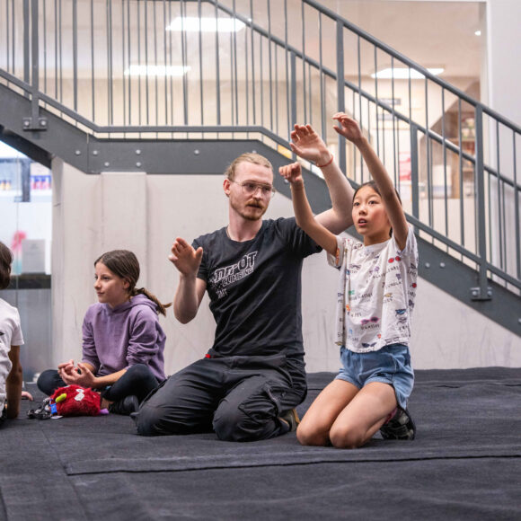 schools climbing instructor helps a young female climber visualise movement