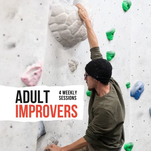 adult coaching improvers participant climbing a large white hold