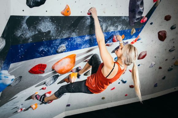 Blonde woman climbing at an indoor bouldering gym
