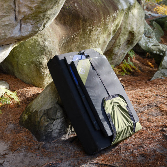 Core Climbing bouldering mats lean against a boulder